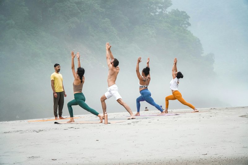 Group yoga practice on a misty beach